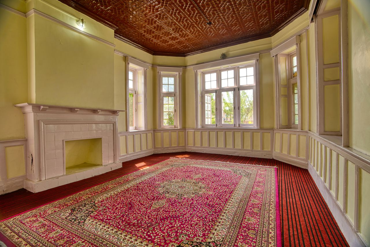 The Art of Drawing Readers In: Your attractive post title goes here A spacious, elegant room with large windows, fireplace, and vibrant carpet in Jammu and Kashmir.